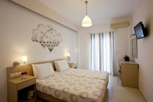 a small bedroom with a bed and a television at Hippocampus Hotel in Kamari