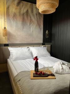a bed with a tray of food and wine glasses on it at MikroKlimat Premium in Jarosławiec