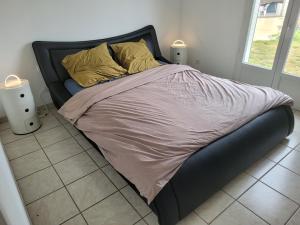 1 cama grande con marco negro en un dormitorio en B&B BonjourSoleil en Tourouzelle