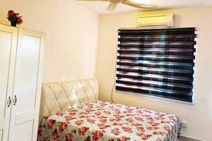 1 dormitorio con cama y ventana con cortina en Homestay Kampar Putra en Kampar