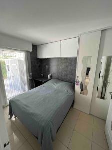 a bedroom with a bed in a room at Magnifique 2 pièces, jardin et parking in Saint-Laurent-du-Var
