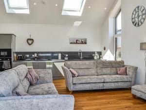 a living room with two couches and a kitchen at Fell View Cottage - Uk43378 in Kirklinton