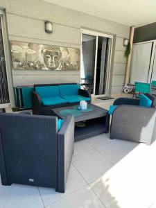 a living room with a couch and a table and chairs at Magnifique 2 pièces, jardin et parking in Saint-Laurent-du-Var
