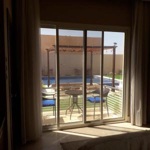 a window with a view of a patio with a table at Blue Revan chalet in Salalah