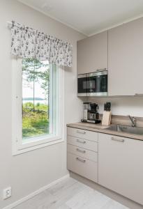 a kitchen with white cabinets and a window at Albatross 