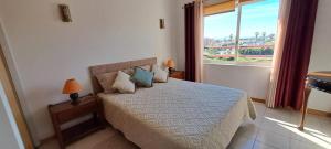 - une chambre avec un lit et une grande fenêtre dans l'établissement Remarkable 1 Bedroom Apartment Costa da Caparica, à Costa da Caparica