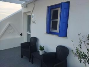 a room with two chairs and a blue window at Maistrali in Provatas