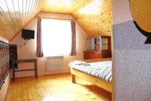 a bedroom with a bed and a large window at Садиба У Романа 'корпус із сауною' in Verkhneye Sinevidnoye