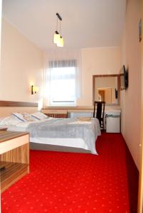 sypialnia z dużym łóżkiem z czerwonym dywanem w obiekcie Willa Nimfa - dla Grup i Gości indywidualnych w Szklarskiej Porębie