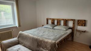 - un lit dans une chambre avec un canapé et une fenêtre dans l'établissement Apartmán č1 Bojnice 450m od centra, à Bojnice