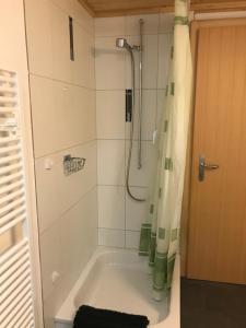 bundb-wyssen-matten في Matten: حمام مع حوض استحمام مع دش
