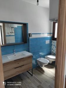 uma casa de banho com um lavatório e um WC em Appartement F2 meublé em Loculi