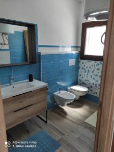 uma casa de banho azul com um WC e um lavatório em Appartement F2 meublé em Loculi