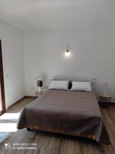 um quarto com uma cama grande e pisos em madeira em Appartement F2 meublé em Loculi