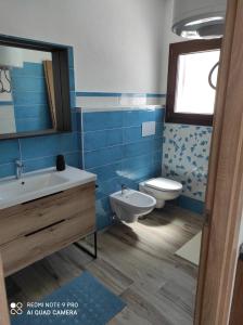 uma casa de banho azul com um WC e um lavatório em Appartement F2 meublé em Loculi