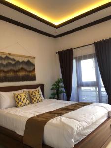 une chambre avec un grand lit et une fenêtre dans l'établissement K'PANDAWA COTTAGE SITUBONDO, à Situbondo