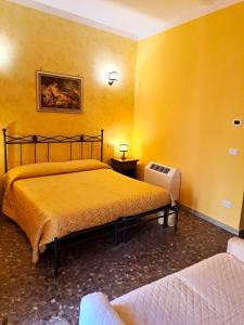 Habitación amarilla con 2 camas y radiador en Bed And Breakfast Camere Primavera en Fondi