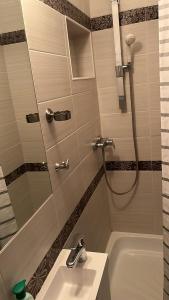 La salle de bains est pourvue d'une douche, d'un lavabo et d'une baignoire. dans l'établissement Apartment Váci, à Budapest