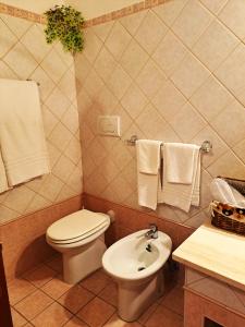 a bathroom with a toilet and a sink with towels at Bed And Breakfast Camere Primavera in Fondi