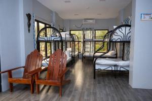 a room with four bunk beds and two chairs at La Jose Beach Resort in Pagudpud