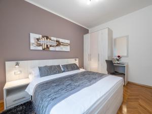 a bedroom with a large white bed and a desk at Apartments Zlatko and Mira Dorcic in Baška