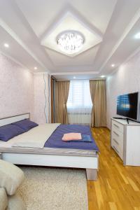 1 dormitorio con 1 cama grande y TV en Центр. Хмельницького. 2 спальні, en Ternopilʼ