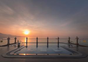 einen Pool auf dem Deck eines Kreuzfahrtschiffs bei Sonnenuntergang in der Unterkunft 7 Seven Sea Hotel in Đà Nẵng