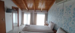 a bedroom with a white bed and a window at Chloe attic in Agia Effimia