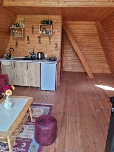 a kitchen in a log cabin with a wooden floor at Cabins Tvishi Near Khvamli Mountain in Tvishi +12 photos