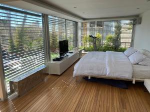 a bedroom with a bed and a tv and windows at Charming Architect Loft withTerrace in Beirut