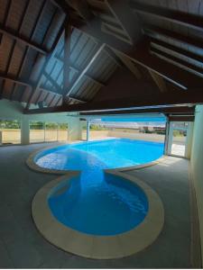 une grande piscine d'eau bleue dans un bâtiment dans l'établissement Appartement Les Pics d'Aran, à Luchon