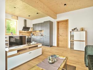 a living room with a television and a kitchen at PureEscape in Faistenau