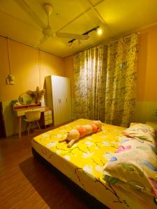 a bedroom with a bed with a yellow comforter at Am Homestay Rembau in Rembau