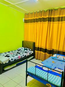 a room with two bunk beds and a curtain at Am Homestay Rembau in Rembau