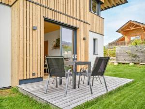 una terraza de madera con mesa y sillas. en PureEscape en Faistenau