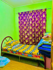 a bedroom with a bed and a curtain at Am Homestay Rembau in Rembau