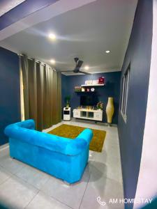 a blue couch in a living room with blue walls at Am Homestay Rembau in Rembau