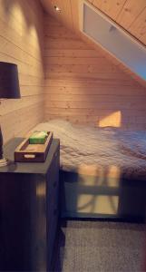 ein Schlafzimmer mit einem Bett in einem Holzzimmer in der Unterkunft Unique Barnhouse in Amazing Gimsøy in Lofoten in Saupstad