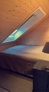 Bett in einem Holzzimmer mit Fenster in der Unterkunft Unique Barnhouse in Amazing Gimsøy in Lofoten in Saupstad
