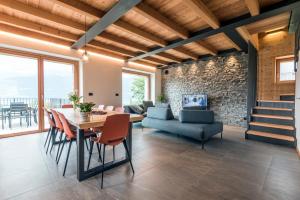a dining room and living room with a table and chairs at La cà del Bisun in Colico