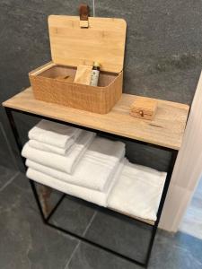 a wooden shelf with towels and a box on it at Absentia 1763 Garda Boutique Home - Lake front in Brenzone sul Garda