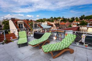 three chairs on a balcony with a view of a city at Residence Art Guest House in Plovdiv