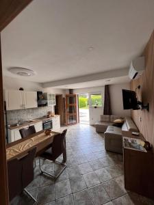 een keuken en een woonkamer met een tafel en een bank bij Spacious apartment in nature with infrared sauna! in Postojna
