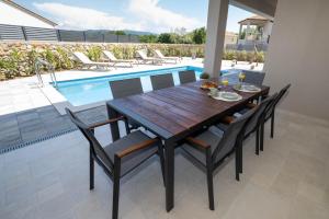 Una mesa de comedor y sillas junto a una piscina. en Holiday house JEWEL with private pool, en Kornić 32 fotos más