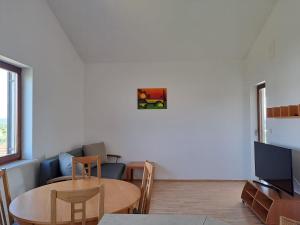 een woonkamer met een tafel en een televisie bij Apartments Pavlovic in Ninski Stanovi