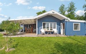 a blue tiny house with a patio and a yard at Nice Home In Or With House Sea View in Orø