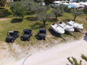 an aerial view of three jeeps and boats in a field at Alexandros Hotel Apartments in Vourvourou