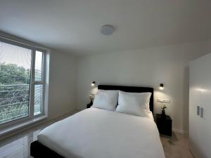 ポドハイスカにあるGRAND HYATT APPARTMENTSの白いベッドルーム(大型ベッド1台、窓付)