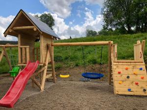 un parque infantil con tobogán y columpio en Bystre DOMKI 2, en Nowe Bystre