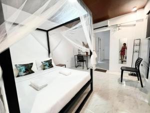 ゼネラル・ルナにあるMahajab Homestay SIARGAOのベッドルーム(天蓋付き白いベッド1台付)